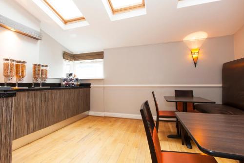 a dining room with a bar and a table at The Abbey Lodge Hotel in Bradford