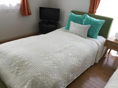 a bedroom with a bed with blue and white pillows at La Curación in Naoshima