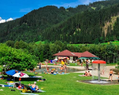 a group of people laying on the grass at a park at Landhotel Berger in Eben im Pongau