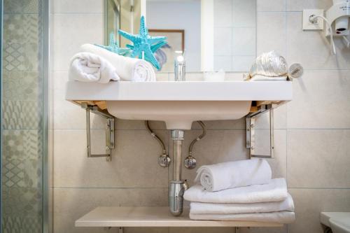 a bathroom with a sink and a pile of towels at Petit Malaga Congress in Málaga