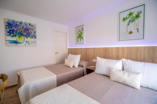 a hotel room with two beds and paintings on the wall at Petit Malaga Congress in Málaga