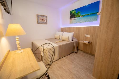 a small room with a bed and a lamp at Petit Malaga Congress in Málaga
