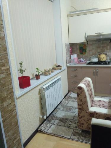 a small kitchen with a chair and a radiator at Sweet home Gusar. in Qusar