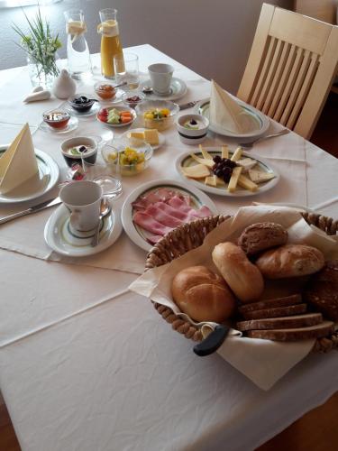 a table with a white table cloth with food on it at Gästehaus Appartements Egender in Bezau