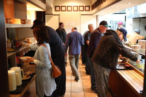 a group of people standing in a kitchen preparing food at Hotel New Yokosuka in Yokosuka