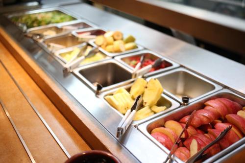 a buffet line with trays of fruits and vegetables at Hotel New Yokosuka in Yokosuka