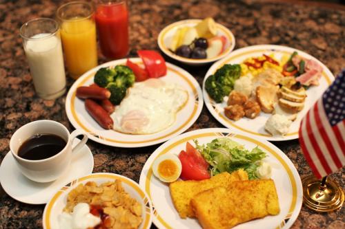 a table with plates of breakfast foods and drinks at Hotel New Yokosuka in Yokosuka
