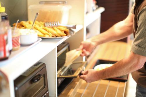 a man is putting a plate of fries in an oven at Hotel New Yokosuka in Yokosuka