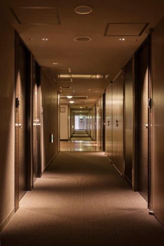 an empty corridor in a building with doors and ceilings at Hotel New Yokosuka in Yokosuka