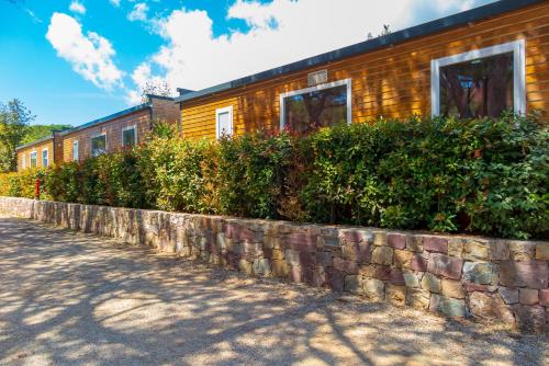 a brick retaining wall next to a building at Camping Lacona Pineta in Capoliveri
