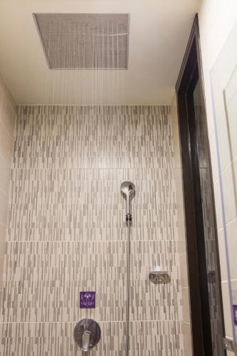 a shower in a bathroom with a tile wall at 富士都商務汽車會館 台南市旅館308號 in Tainan