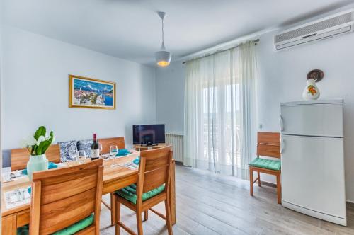 a kitchen and dining room with a table and a refrigerator at Apartments & Bungalows Ivanović in Kaštela