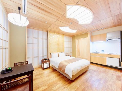 a bedroom with a large bed and a kitchen at Sunrise Suites in Kyoto