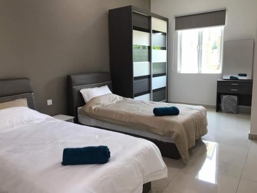 a hotel room with two beds and a mirror at Greenville Homestay in Balik Pulau