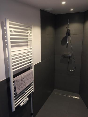 czarna łazienka z prysznicem i wieszakiem na ręczniki w obiekcie Beach lodge w Zandvoort