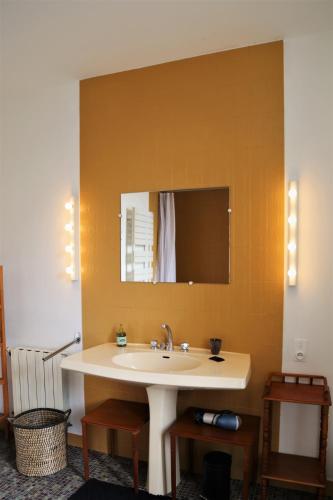 une salle de bain avec un lavabo et un miroir dans l'établissement Le Bonheur- Suite Cognac, à Hiersac