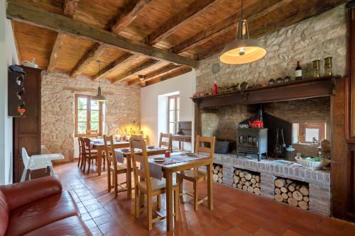 eine Küche und ein Esszimmer mit einem Tisch und einem Kamin in der Unterkunft Chambres et table d'hôtes La Panacée in Cuzance