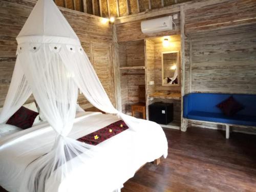 a bedroom with a white bed with a canopy at Naradas Mushroom Beach in Nusa Lembongan