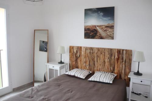 a bedroom with a bed with a wooden headboard at 205 route de la turbie in Èze