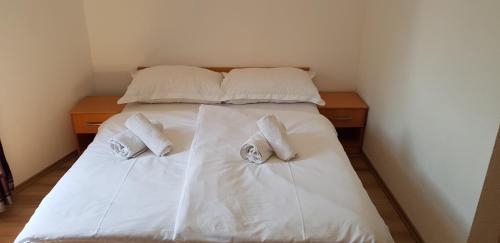 a bed with white sheets and towels on it at Pansion Bojic in Međugorje