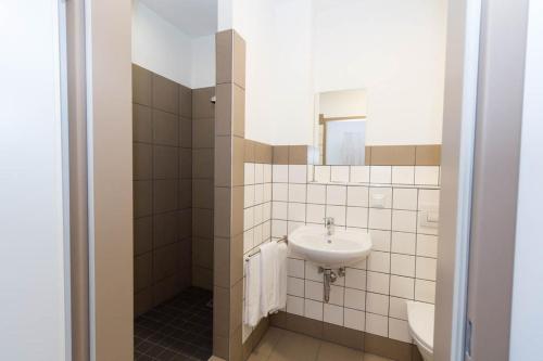 a white bathroom with a sink and a mirror at WinBudget Guntramsdorf in Guntramsdorf