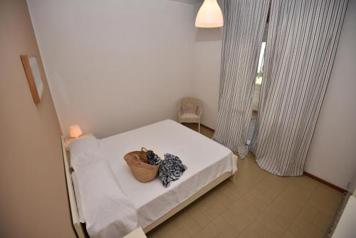 una piccola camera con un letto con un cesto di Residence Blùmarine a Silvi Marina