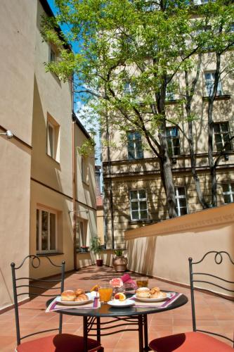 una mesa con dos platos de comida en un patio en Hotel Caesar Prague, en Praga