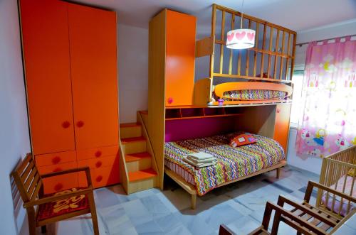 エステポナにあるAlcazaba Beach Apartment 3302の子供用ルーム 二段ベッド1組、ベビーベッド1台付