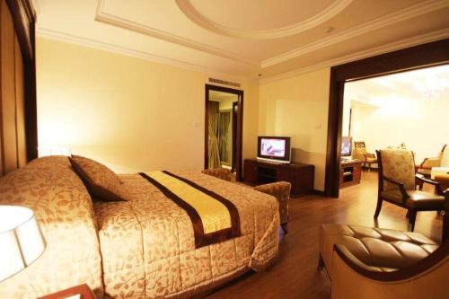 a hotel room with a bed and a television at LK Residence in Pattaya Central