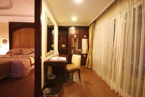 a bedroom with a bed and a desk and a mirror at LK Residence in Pattaya Central