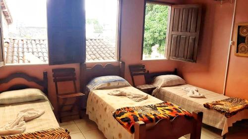a room with three beds and a window at Pousada Labarca in Cachoeira