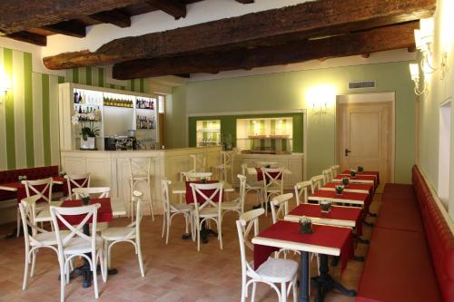 un ristorante con tavoli e sedie rossi e bianchi di Hotel Borgo Antico a Como