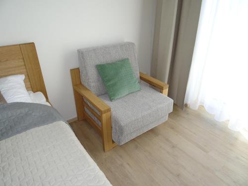 a bedroom with a chair and a bed with a pillow at Apartmány Sport Dolní Morava in Dolní Morava