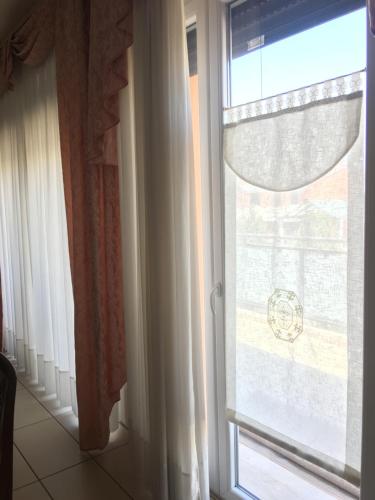 a window with a white curtain in a room at App4rent Family Apartment 3 camere, 2 bagni, Wi-Fi, animali ammessi in Jesolo