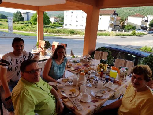 a group of people sitting around a table at Pansion Bojic in Međugorje