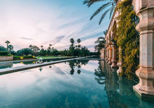 a reflection of a building in a canal at Palais Namaskar in Marrakech