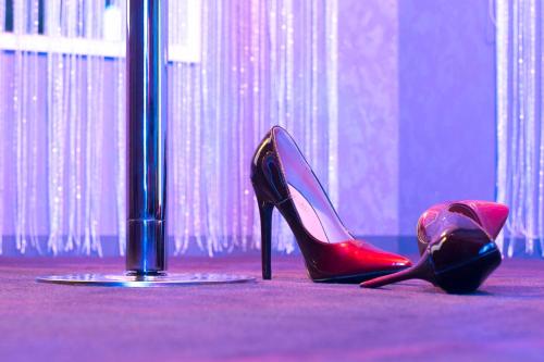 une paire de talons rouges et un poteau dans l'établissement Love room proche Rennes Le Cocon Enchanteur, à Plélan-le-Grand