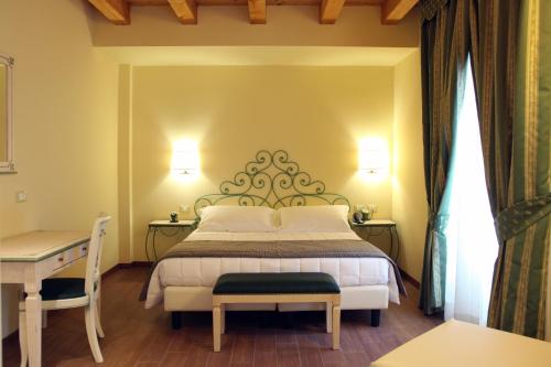 una camera con letto, scrivania e letto Sidx Sidx Sidx di Hotel Borgo Antico a Como