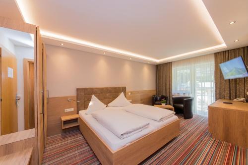 ザールバッハ・ヒンターグレムにあるLandhotel Oberdannerのベッドとデスクが備わるホテルルームです。