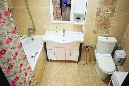 Un baño con lavabo, inodoro y ducha. en Luxury Palace Apartment, en Bishkek