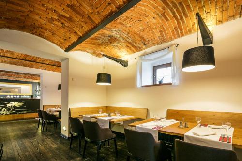 a restaurant with tables and chairs and a brick ceiling at Pytloun Self Check-in Hotel Liberec in Liberec