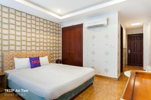 a bedroom with a bed with a purple pillow on it at Mays Hotel- Ben Thanh Market in Ho Chi Minh City