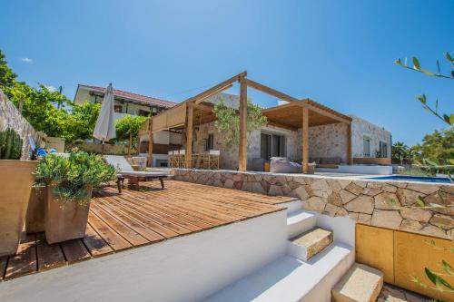 a backyard with a wooden deck and a swimming pool at Niova Villa in Alykes