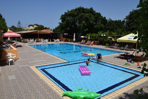 uma grande piscina com pessoas a brincar nela em Camping Chania em Kato Daratso