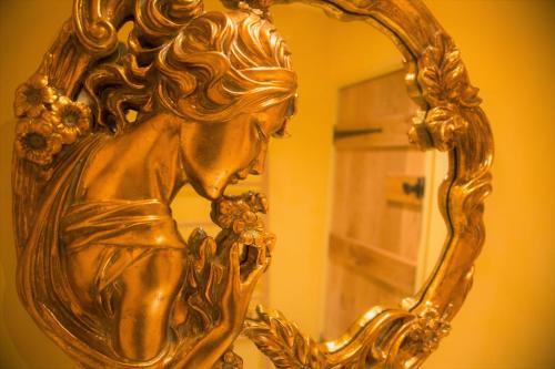 a gold statue of a woman looking in a mirror at St.Michaels Bistro in Painswick