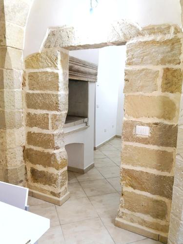 a room with a stone wall and a fireplace at CASA TIPICA indipendente in Carpignano Salentino