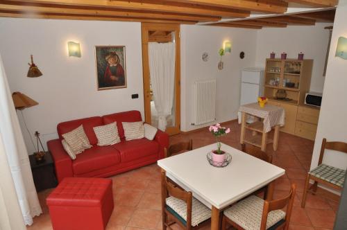 un soggiorno con divano rosso e tavolo di Casa Vela a Ledro