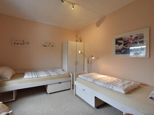 a bedroom with two beds and a refrigerator at Spacious Holiday Home in Wismar Germany with Parasol in Wismar