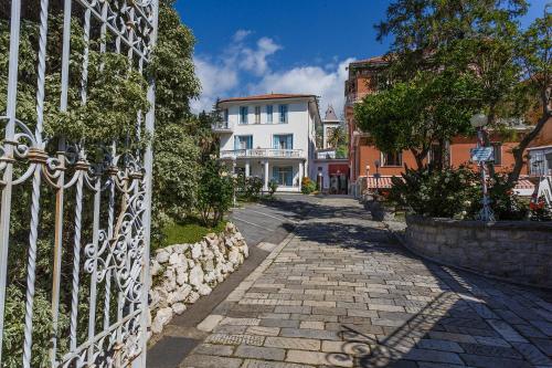 a cobblestone street with a white house and a gate at Hotel Villa Maria in Sanremo