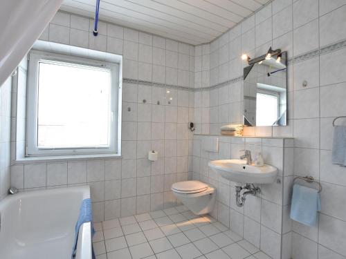 ein Badezimmer mit einem WC, einem Waschbecken und einer Badewanne in der Unterkunft Spacious Holiday Home in Wismar Germany with Parasol in Wismar